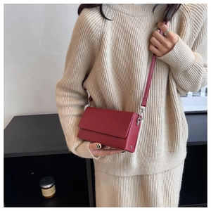 Detail of red small square crossbody bag with Forever Young text and silver hardware