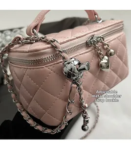 Detail of pink quilted box bag showing the adjustable metal ball on the chain strap