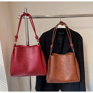 Detail view of vintage burgundy and brown bucket bags with elegant knotted shoulder straps