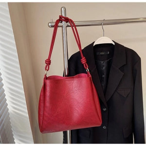 Detail of red PU leather tote bag with knotted straps and Fashion & Bag Paris logo