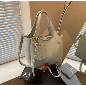Light blue bucket bag with pebble leather texture and a cute puppy charm detail