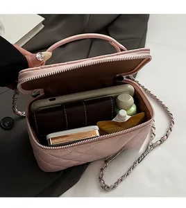 Detail of light pink quilted mini bag showing interior storage space and metal chain strap