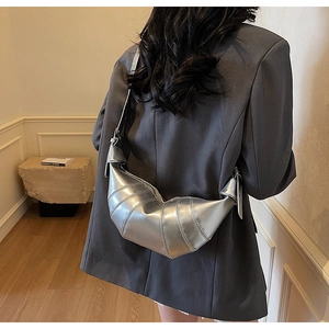 Macro detail of silver quilted croissant bag with metallic finish and crescent shape