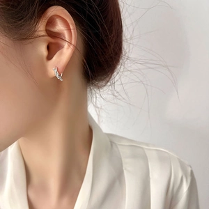 Minimalist S925 sterling silver twisted knot hoop earrings worn on a model's ear