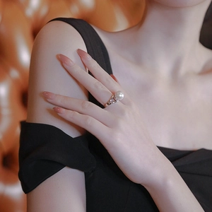 Elegant single pearl ring with a crossover silver band shown on a model's hand