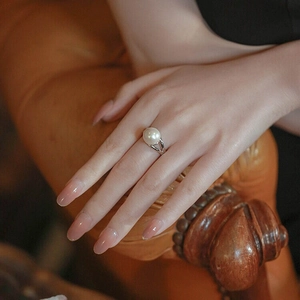 Elegant large round pearl ring with silver split band design worn on hand in a soft setting