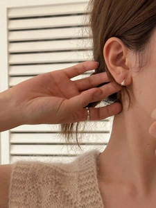 Vue détaillée de boucles d'oreilles perles minimalistes et d'une bague argentée