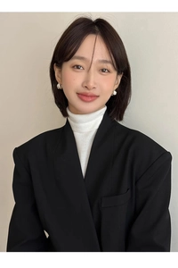 Close-up of irregular silver C-shaped floral earrings on a model in a black blazer