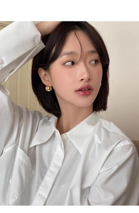 Close-up of elegant gold thick hoop earring on model with mirror-polished finish