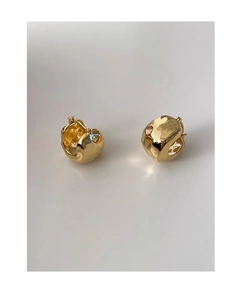 Close-up of gold irregular hammered texture metal hoop earrings for a minimalist look