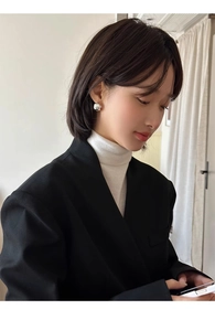 Close-up of irregular geometric silver stud earring worn by a model in a minimalist style