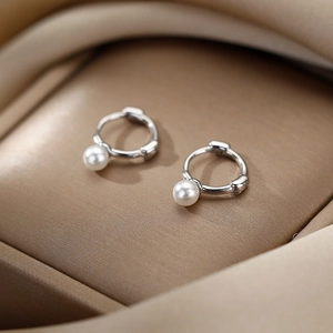 Créoles minimalistes en argent avec perles blanches sur tissu de soie champagne élégant