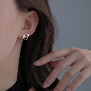Boucles d'oreilles créoles en argent avec perles blanches portées par un mannequin