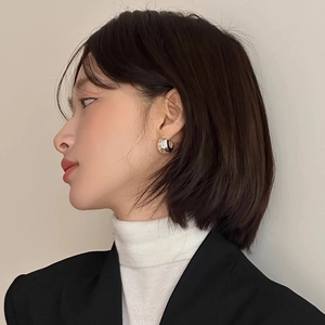 Irregular silver metal hoop earrings with round spherical design on professional model