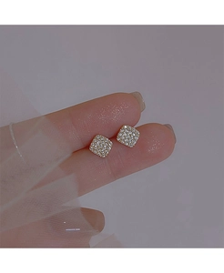 Macro detail of geometric gold stud earrings with micro-pave white zircon inlay