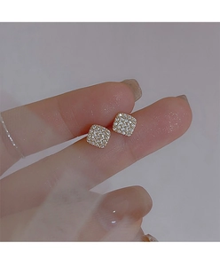 Close-up of geometric square stud earrings featuring micro-paved cubic zirconia stones
