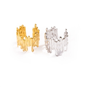 Anelli asimmetrici minimalisti effetto lava in oro e argento su sfondo bianco