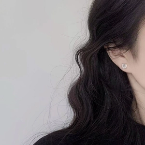 Minimalist geometric square stud earrings with cubic zirconia on a model's ear