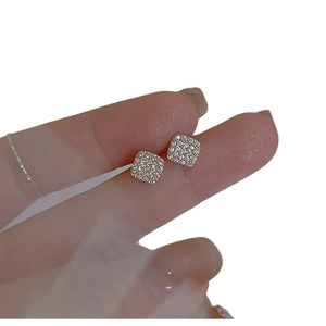 Geometric gold square stud earrings with pave-set zircon stones on white background