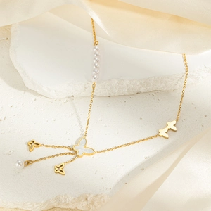 Elegant gold titanium butterfly heart necklace with pearls and double tassels on silk background