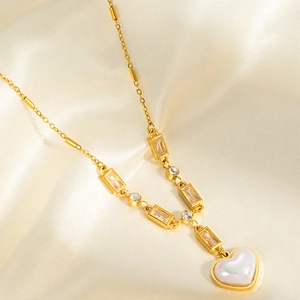 Macro detail of gold necklace featuring heart-shaped pendant with luminous opal finish