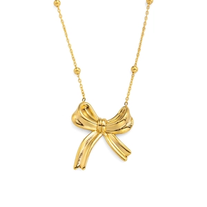 Detailed view of a 3D bow pendant necklace in polished gold finish with a dainty chain
