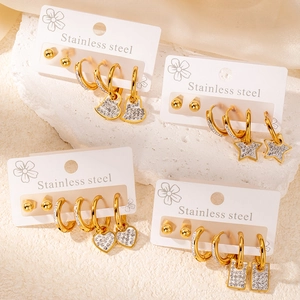 Détail du lot de boucles d'oreilles en acier doré avec breloques cœur et étoile