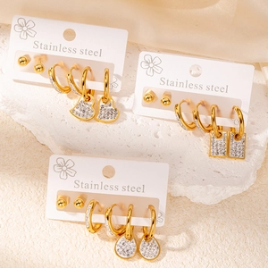 Détail d'un ensemble de boucles d'oreilles en acier doré avec pendentifs en zircon