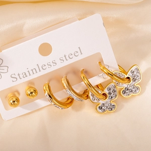 Détail de l'ensemble de boucles d'oreilles en acier doré avec papillons et zircons
