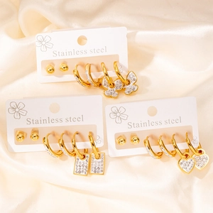 Set de trois paires de boucles d'oreilles en acier doré avec breloques cœur et papillon