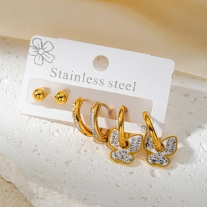 Détail d'un ensemble de trois boucles d'oreilles dorées en acier et strass sur carte