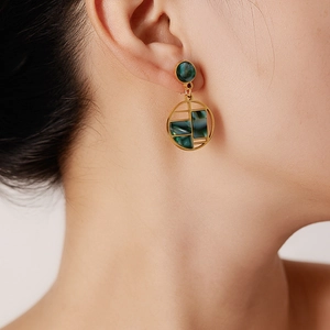 Close-up of vintage 18K gold butterfly earrings with dark green marble texture for women