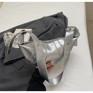 Detail of silver metallic croissant bag with quilted faux leather and adjustable strap