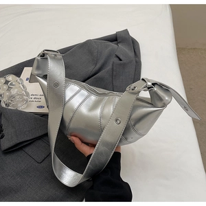 Detailed view of silver metallic croissant bag with pleated design and buckled strap