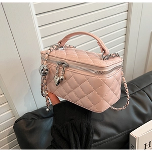 Close-up of pink quilted box bag featuring silver chain strap and sweet heart metal charms