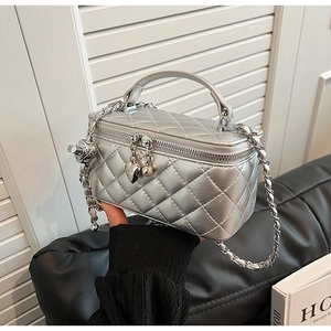 Close-up of silver quilted box bag with heart zipper pull and metal chain strap
