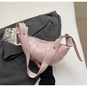 Detail of pink croissant bag with quilted stitching and adjustable silver eyelet strap