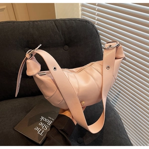 Close-up of pink crescent bag showing PU leather texture and silver metal buckle