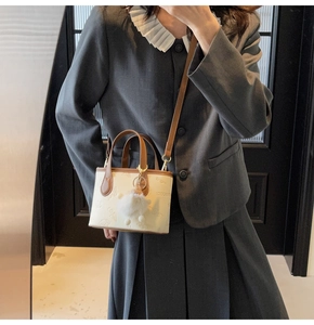 Chic embossed handbag with bear and butterfly patterns shown on a model