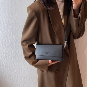 Minimalist black rectangular crossbody bag with matte leather finish and silver hardware