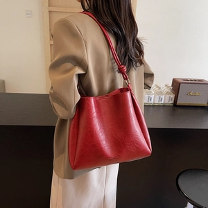 Vintage burgundy tote bag with knot strap detail, retro leather texture bucket bag