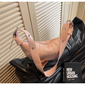 Detail of pink croissant shoulder bag with pleated leather and metallic grommet strap