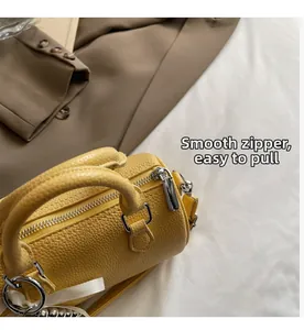 Détail du sac jaune à texture litchi montrant le zip argenté fluide et le foulard en soie