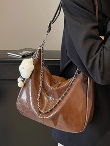 Brown vintage hobo tote bag in glossy faux leather with chain and plush charm