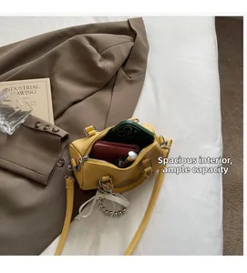 Vue intérieure d'un mini sac Boston jaune en cuir grainé montrant sa grande capacité