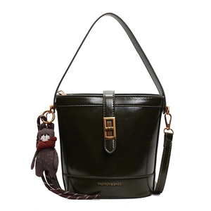 Borsa a secchiello verde bosco lucido con finiture dorate e ciondolo orsetto soft