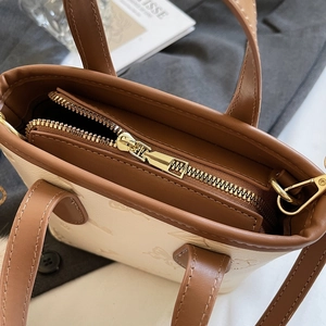 Chic embossed women's bucket bag in cream and brown with decorative metal zipper top