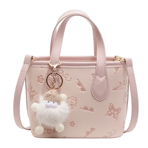 Pink embossed bucket bag with floral patterns, adjustable strap and a plush monster charm