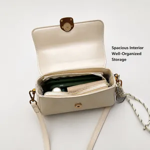 Interior view of off-white leather shoulder bag with spacious compartments and gold clasp