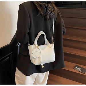 Back view of white lychee leather bucket bag with puppy tag and fashion printing